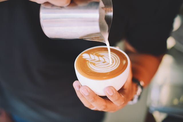 someone pouring a latte