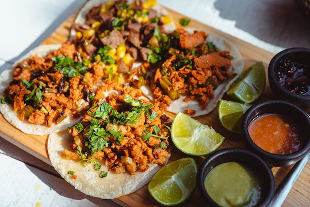 a board full of chicken tacos and Mexican food