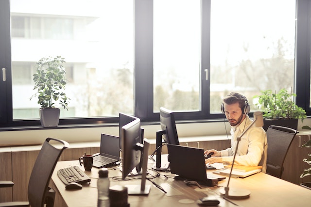 professional wearing headphones in front of a computer