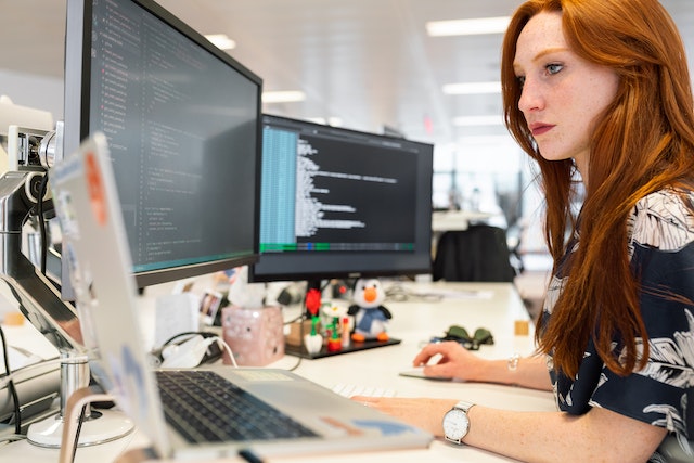 employee at desk looking at computers