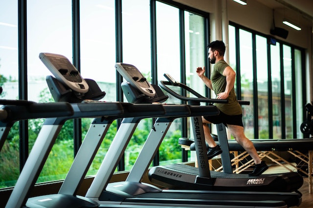 person running on a treadmill in front of windows